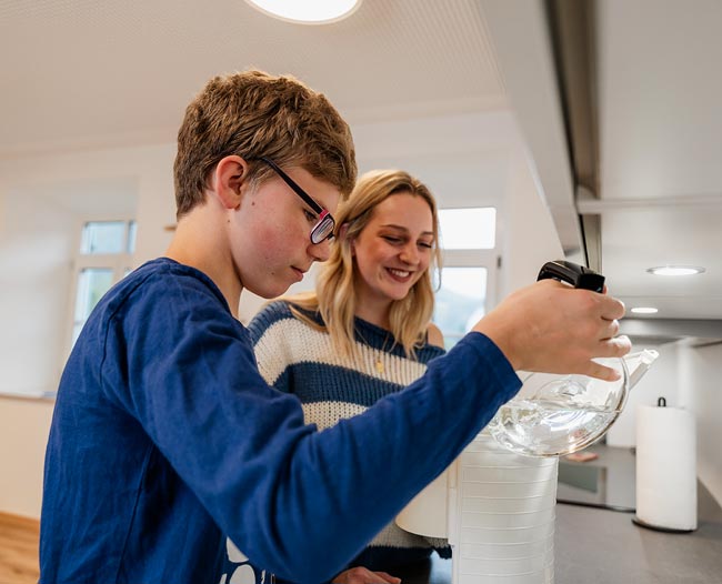 img-6 Pflegekind füllt Wasser in einen Wasserkocher
